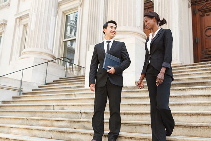 Two attorneys talking on the steps of a courthouse.