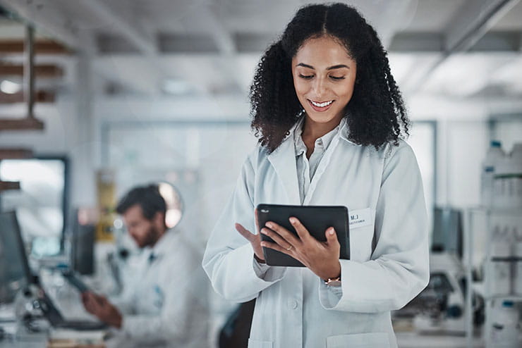 Black female engineer analyzing innovative technological research data on her tablet in the laboratory.
