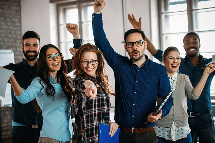 Group of people in an office cheering.