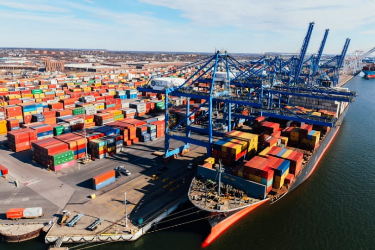 Shipyard with many containers using artificial intelligence, autonomous trucking and the sharing economy to operate a smooth supply chain.