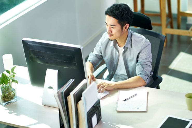 man typing in front of a computer