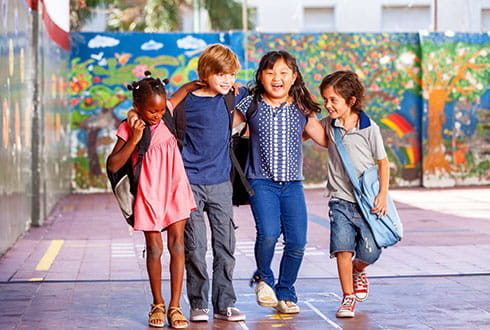 Amis de l'école élémentaire jouant dans l'aire de jeux pour enfants.